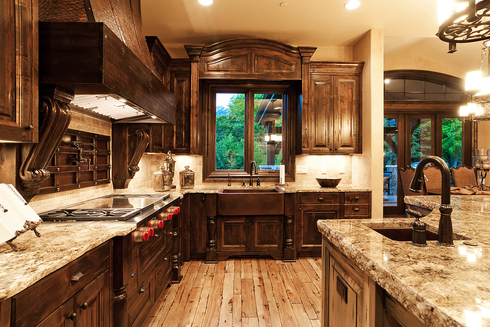 Large mountain style galley light wood floor eat-in kitchen photo in Salt Lake City with a farmhouse sink, raised-panel cabinets, dark wood cabinets, granite countertops, beige backsplash, porcelain backsplash, stainless steel appliances and an island