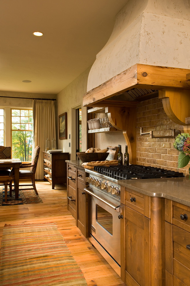 На фото: кухня в классическом стиле с обеденным столом в частном доме
