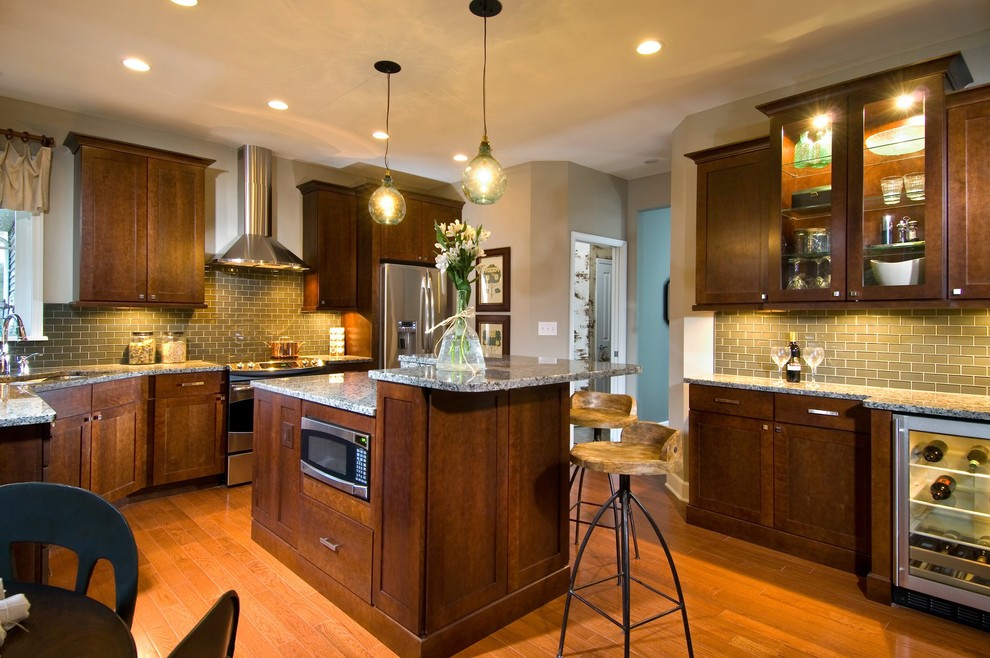Exempel på ett modernt kök, med stänkskydd i glaskakel, rostfria vitvaror, grönt stänkskydd och skåp i mörkt trä
