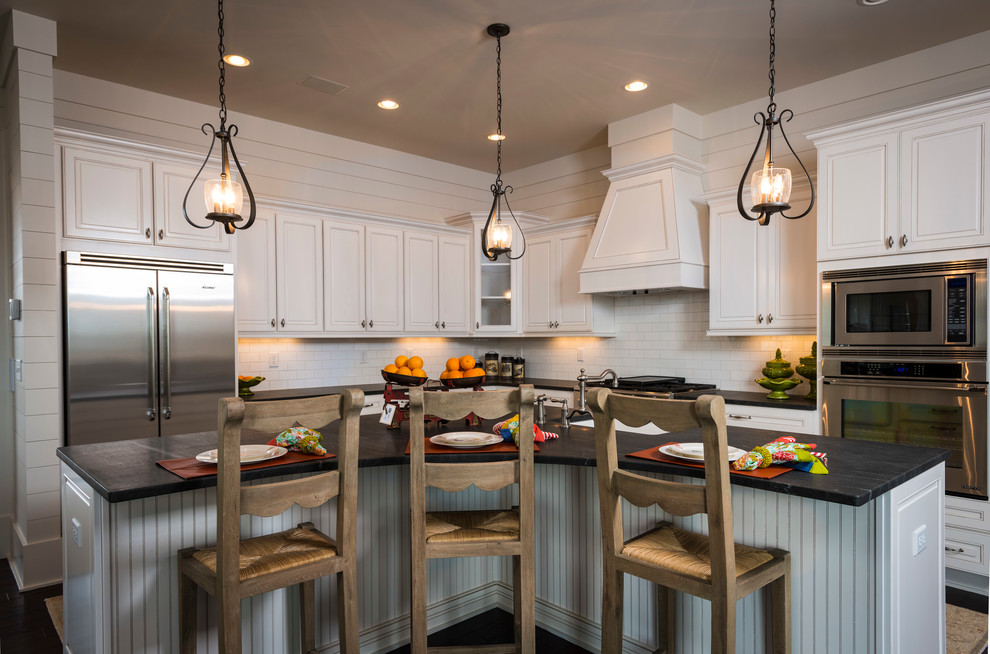 アトランタにあるトラディショナルスタイルのおしゃれなキッチン (レイズドパネル扉のキャビネット、白いキャビネット、白いキッチンパネル、サブウェイタイルのキッチンパネル、シルバーの調理設備) の写真