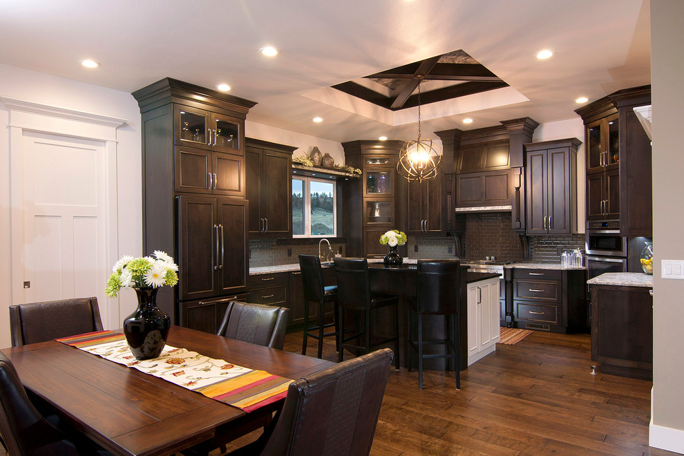 Exempel på ett mellanstort klassiskt vit vitt kök, med en undermonterad diskho, luckor med infälld panel, skåp i mörkt trä, bänkskiva i kvartsit, brunt stänkskydd, stänkskydd i glaskakel, rostfria vitvaror, mellanmörkt trägolv och en köksö