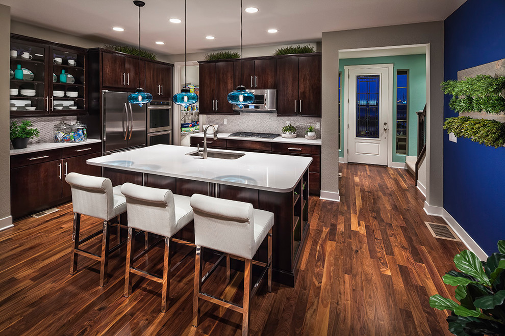 Example of a trendy brown floor kitchen design in Denver with an undermount sink, flat-panel cabinets, dark wood cabinets, gray backsplash, stainless steel appliances and gray countertops