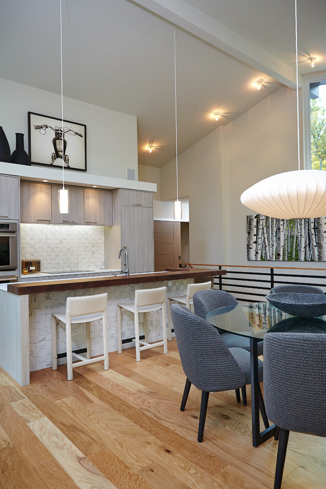 Photo of a midcentury galley kitchen/diner in Grand Rapids with flat-panel cabinets, medium wood cabinets, wood worktops, white splashback and integrated appliances.