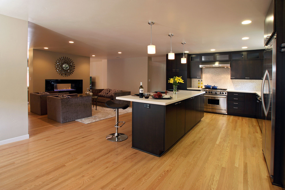 Design ideas for a large contemporary l-shaped open plan kitchen in San Francisco with dark wood cabinets, light hardwood flooring and an island.