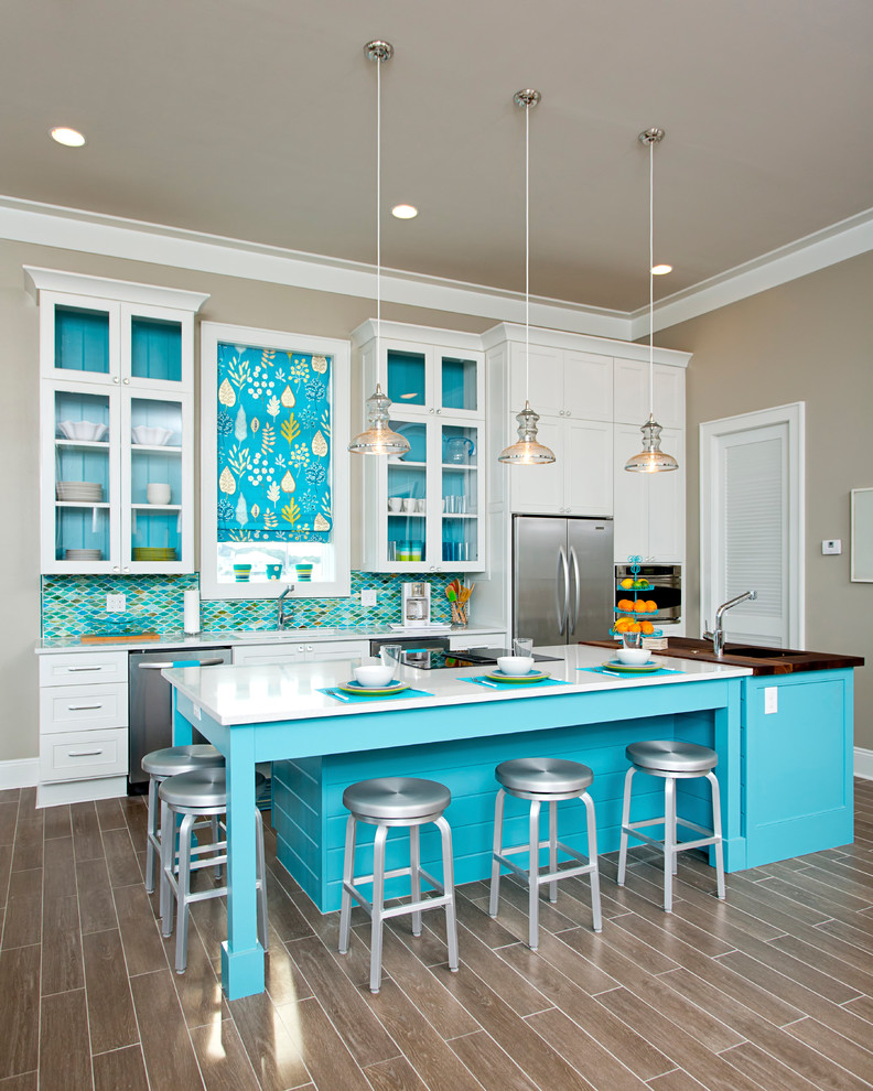 Beach style galley kitchen photo in Other with shaker cabinets, white cabinets, multicolored backsplash, mosaic tile backsplash, stainless steel appliances and an island