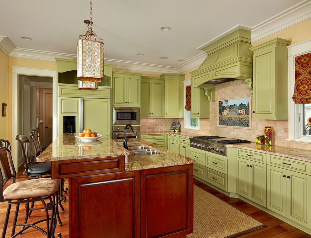 Exempel på ett klassiskt kök, med stänkskydd i stenkakel, granitbänkskiva, gröna skåp, integrerade vitvaror, beige stänkskydd, en köksö, luckor med upphöjd panel och en undermonterad diskho