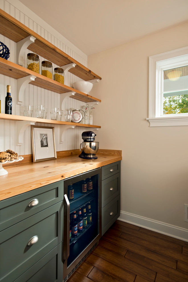 Diseño de cocina tradicional con armarios estilo shaker, puertas de armario verdes, encimera de madera y electrodomésticos de acero inoxidable