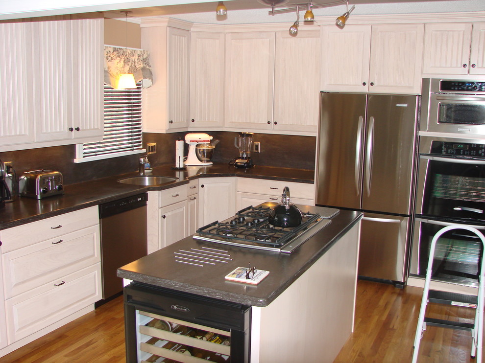 Foto de cocina moderna con fregadero bajoencimera, puertas de armario blancas, encimera de acrílico y electrodomésticos de acero inoxidable