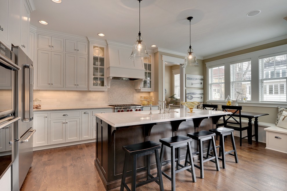 Example of a classic eat-in kitchen design in Minneapolis with stainless steel appliances and stone tile backsplash