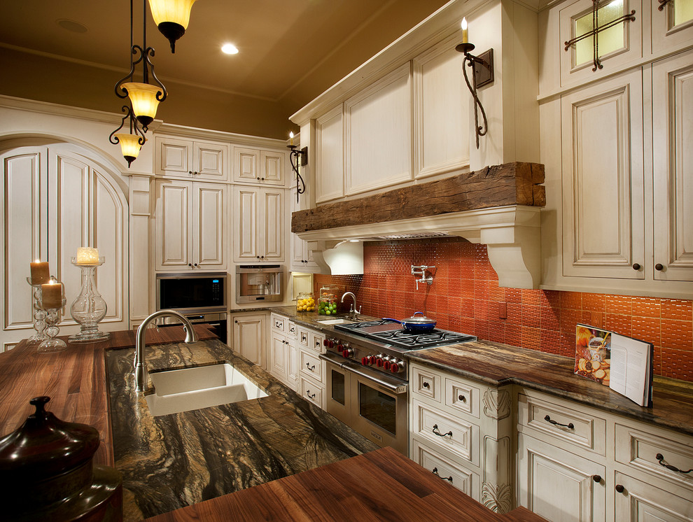Large tuscan u-shaped enclosed kitchen photo in Phoenix with a double-bowl sink, raised-panel cabinets, white cabinets, marble countertops, orange backsplash, mosaic tile backsplash, stainless steel appliances and an island