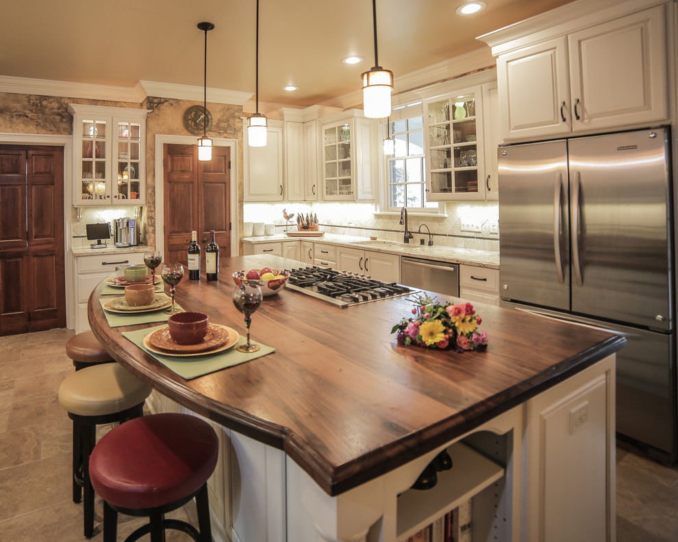 Example of a large arts and crafts eat-in kitchen design in Milwaukee with white cabinets, white backsplash and stainless steel appliances