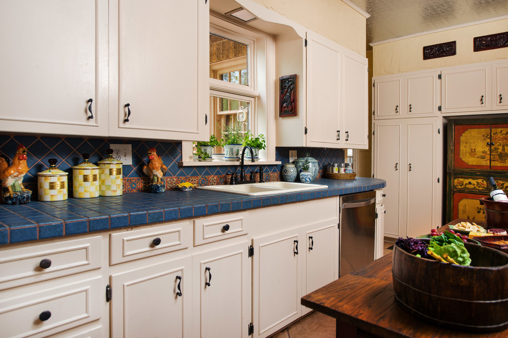 Klassische Küche mit Arbeitsplatte aus Fliesen, Einbauwaschbecken, Küchenrückwand in Blau, weißen Schränken und blauer Arbeitsplatte in Dallas