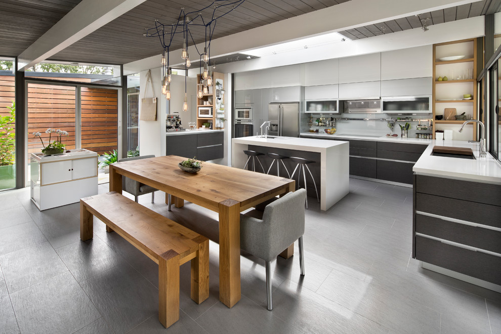 Moderne Küche in L-Form mit flächenbündigen Schrankfronten, grauen Schränken, Küchenrückwand in Weiß, Glasrückwand, Küchengeräten aus Edelstahl, Kücheninsel und grauem Boden in San Francisco