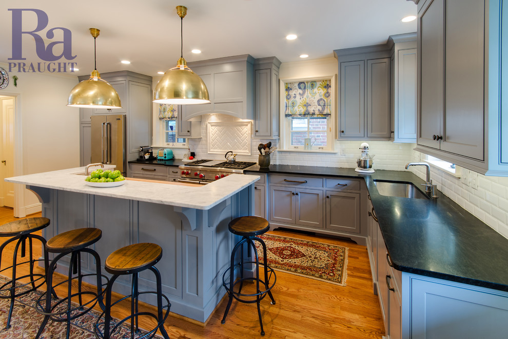 Inspiration for a large u-shaped medium tone wood floor eat-in kitchen remodel in Richmond with an undermount sink, blue cabinets, white backsplash, ceramic backsplash, stainless steel appliances and an island