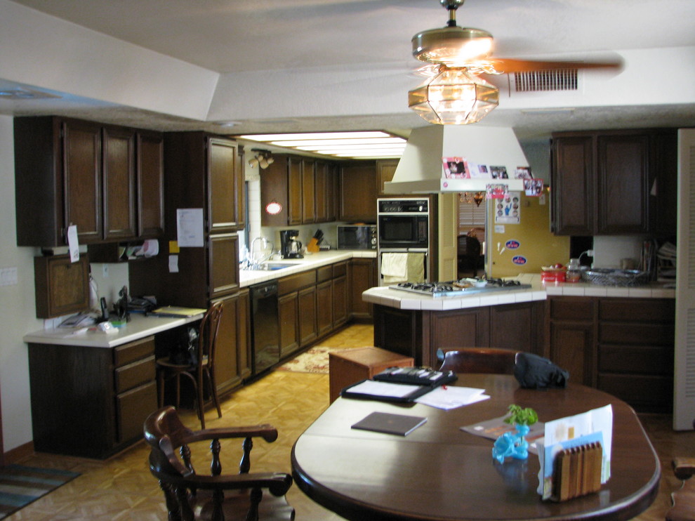 Inredning av ett klassiskt stort kök, med skåp i shakerstil, en trippel diskho, röda skåp, granitbänkskiva, brunt stänkskydd, stänkskydd i stenkakel, rostfria vitvaror, mellanmörkt trägolv och en halv köksö