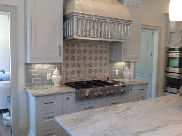 Shabby chic-inspirerad inredning av ett mellanstort kök, med luckor med infälld panel, vita skåp, marmorbänkskiva, grått stänkskydd, stänkskydd i tunnelbanekakel, rostfria vitvaror, en köksö och mörkt trägolv