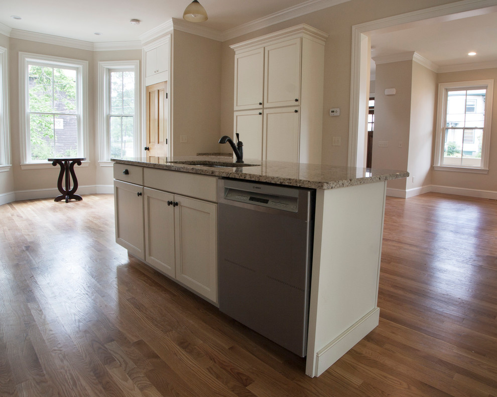 Exempel på ett stort klassiskt linjärt kök och matrum, med beige skåp, granitbänkskiva, flerfärgad stänkskydd, rostfria vitvaror, mellanmörkt trägolv, en köksö och luckor med infälld panel