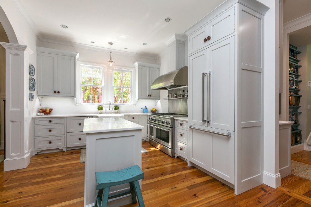 Medium tone wood floor kitchen photo in Charleston with an island, gray cabinets, marble countertops, white backsplash, paneled appliances and a farmhouse sink