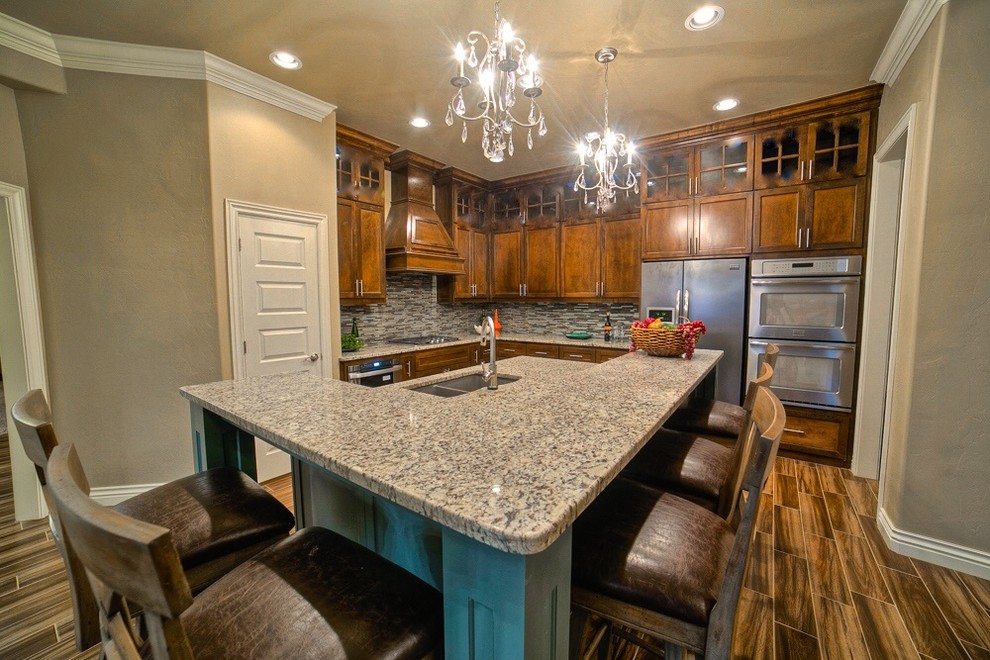 Mid-sized transitional l-shaped vinyl floor open concept kitchen photo in Oklahoma City with a double-bowl sink, shaker cabinets, medium tone wood cabinets, granite countertops, multicolored backsplash, matchstick tile backsplash, stainless steel appliances and an island
