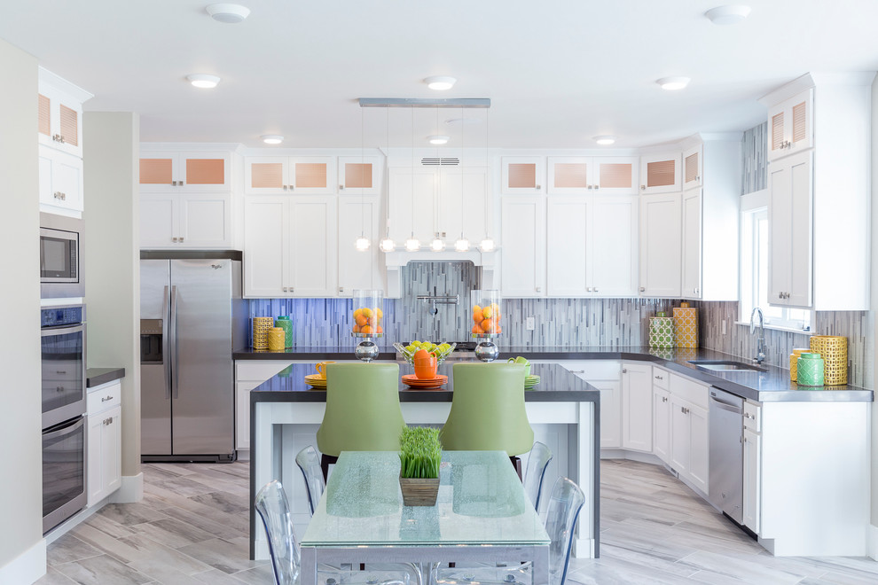 Photo of a large classic u-shaped kitchen/diner in Salt Lake City with a double-bowl sink, shaker cabinets, white cabinets, composite countertops, grey splashback, matchstick tiled splashback, stainless steel appliances, ceramic flooring and an island.
