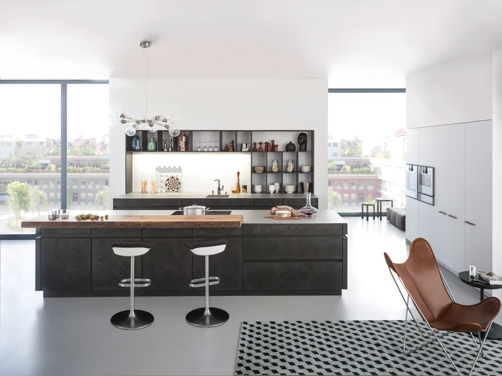 Пример оригинального дизайна: параллельная кухня-гостиная среднего размера в стиле модернизм с врезной мойкой, плоскими фасадами, серыми фасадами, столешницей из бетона, белым фартуком, техникой из нержавеющей стали, бетонным полом и островом