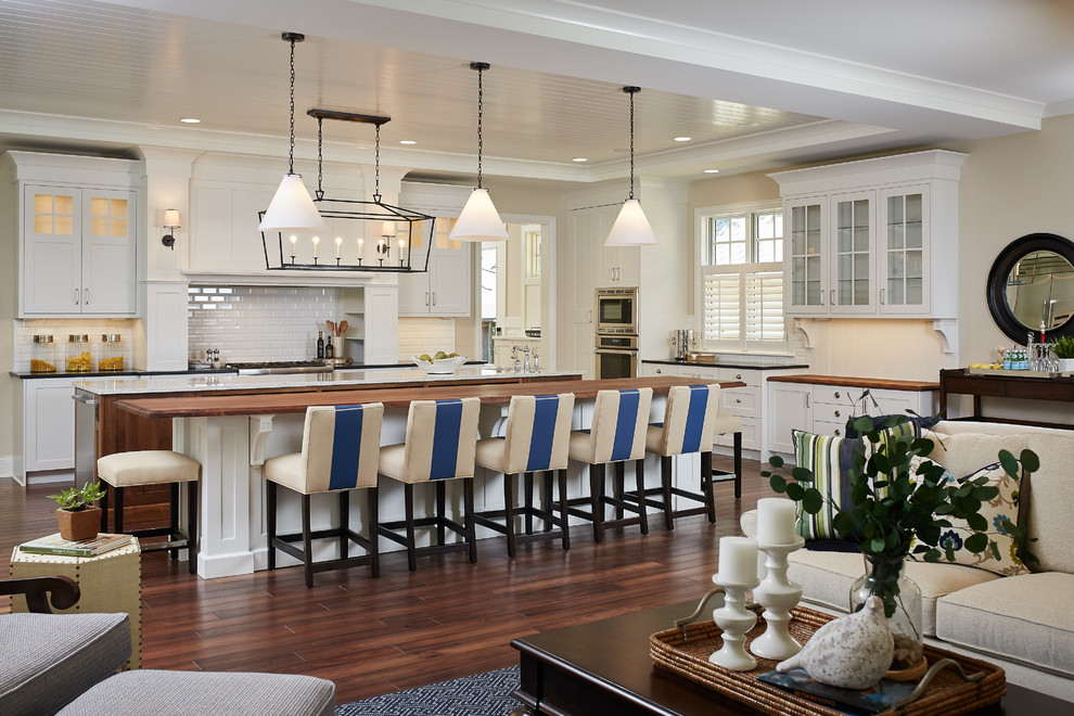 Inspiration for a transitional l-shaped dark wood floor open concept kitchen remodel in Grand Rapids with shaker cabinets, white cabinets, wood countertops, white backsplash, subway tile backsplash, stainless steel appliances and two islands