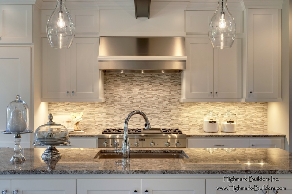 Inspiration for a huge timeless l-shaped light wood floor open concept kitchen remodel in Minneapolis with a double-bowl sink, shaker cabinets, white cabinets, granite countertops, beige backsplash, mosaic tile backsplash, paneled appliances and two islands