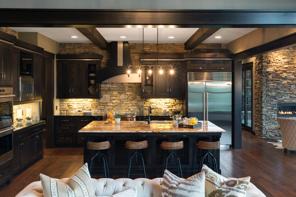 Aménagement d'une cuisine montagne en L avec un évier encastré, un placard à porte shaker, des portes de placard noires, une crédence multicolore, parquet foncé et îlot.