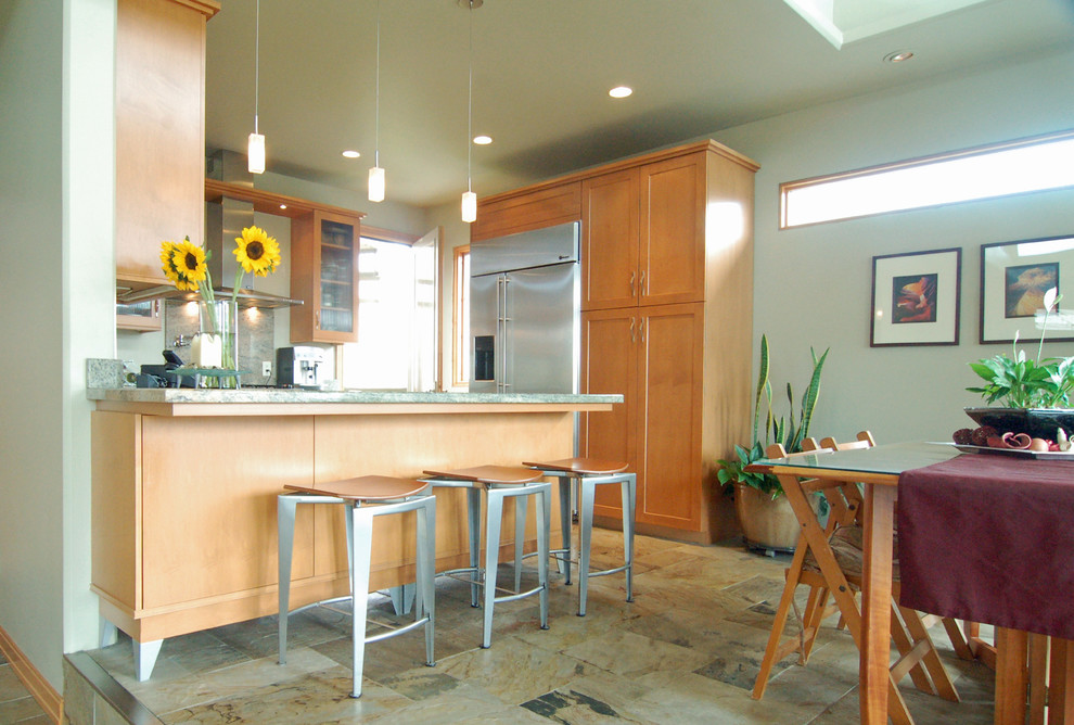 Example of a mid-sized eclectic u-shaped slate floor eat-in kitchen design in San Luis Obispo with shaker cabinets, white cabinets, granite countertops, stone slab backsplash, stainless steel appliances and a peninsula