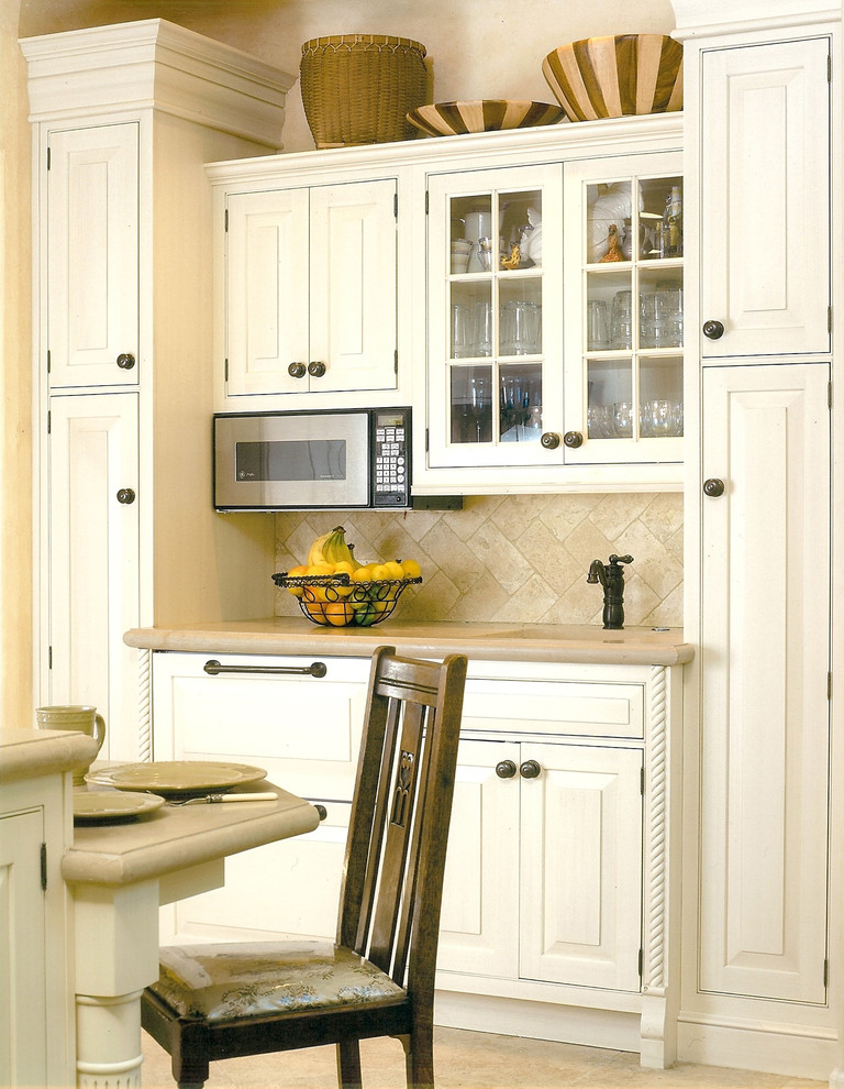 Bild på ett mellanstort medelhavsstil linjärt kök och matrum, med en rustik diskho, luckor med profilerade fronter, vita skåp, bänkskiva i kalksten, beige stänkskydd, stänkskydd i stenkakel, integrerade vitvaror, travertin golv och en köksö