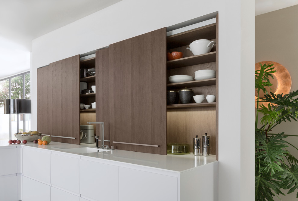 Inspiration for a medium sized modern open plan kitchen in New York with flat-panel cabinets, dark wood cabinets, quartz worktops, stainless steel appliances, an island, an integrated sink and concrete flooring.