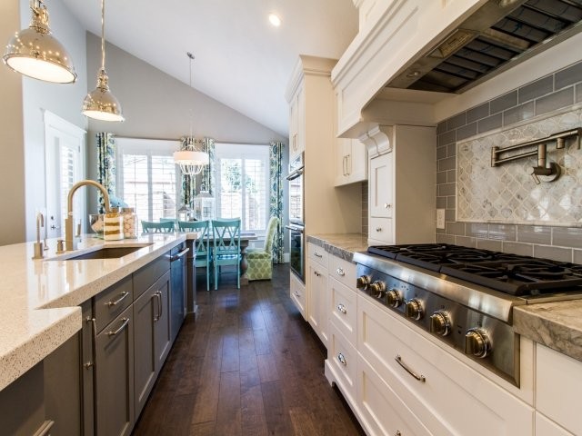 Eat-in kitchen - mid-sized craftsman dark wood floor and brown floor eat-in kitchen idea in Salt Lake City with a single-bowl sink, shaker cabinets, white cabinets, glass countertops, brown backsplash, subway tile backsplash, stainless steel appliances and an island