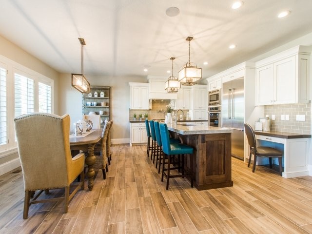 Inspiration for a mid-sized craftsman l-shaped porcelain tile and brown floor eat-in kitchen remodel in Salt Lake City with a single-bowl sink, shaker cabinets, white cabinets, granite countertops, green backsplash, subway tile backsplash, stainless steel appliances and an island