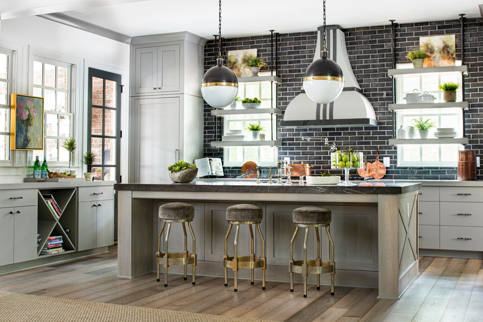 Inspiration for a transitional u-shaped medium tone wood floor kitchen remodel in Atlanta with quartz countertops, an island, flat-panel cabinets, gray cabinets and black backsplash