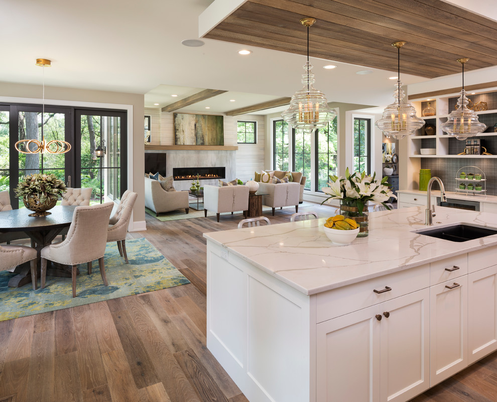 Transitional light wood floor open concept kitchen photo in Minneapolis with an undermount sink, shaker cabinets, white cabinets, black backsplash and an island