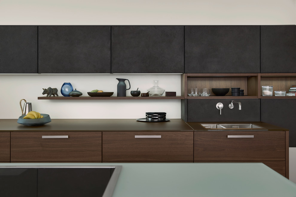 Esempio di una cucina minimalista di medie dimensioni con lavello da incasso, ante lisce, ante grigie, top in superficie solida, paraspruzzi bianco, elettrodomestici in acciaio inossidabile e pavimento in cemento