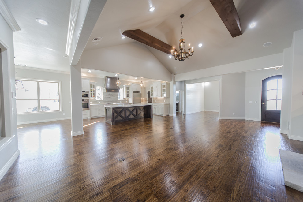 Large transitional l-shaped dark wood floor open concept kitchen photo in Oklahoma City with an undermount sink, shaker cabinets, white cabinets, marble countertops, beige backsplash, stone tile backsplash, stainless steel appliances and an island