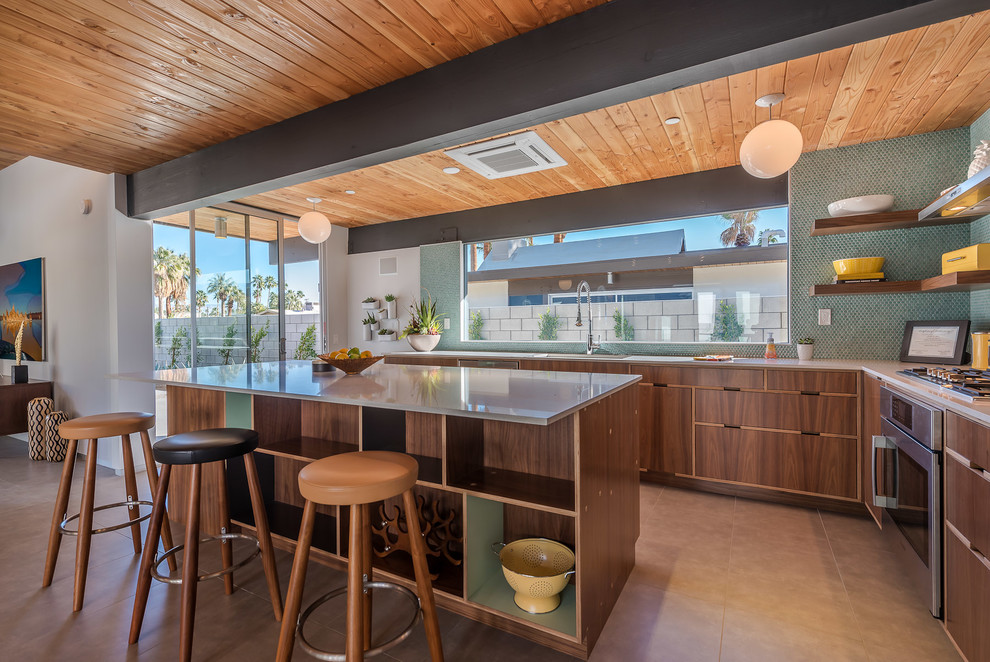 Inspiration for a mid-sized 1950s l-shaped concrete floor eat-in kitchen remodel in Los Angeles with an undermount sink, flat-panel cabinets, dark wood cabinets, quartzite countertops, green backsplash, ceramic backsplash, stainless steel appliances and an island