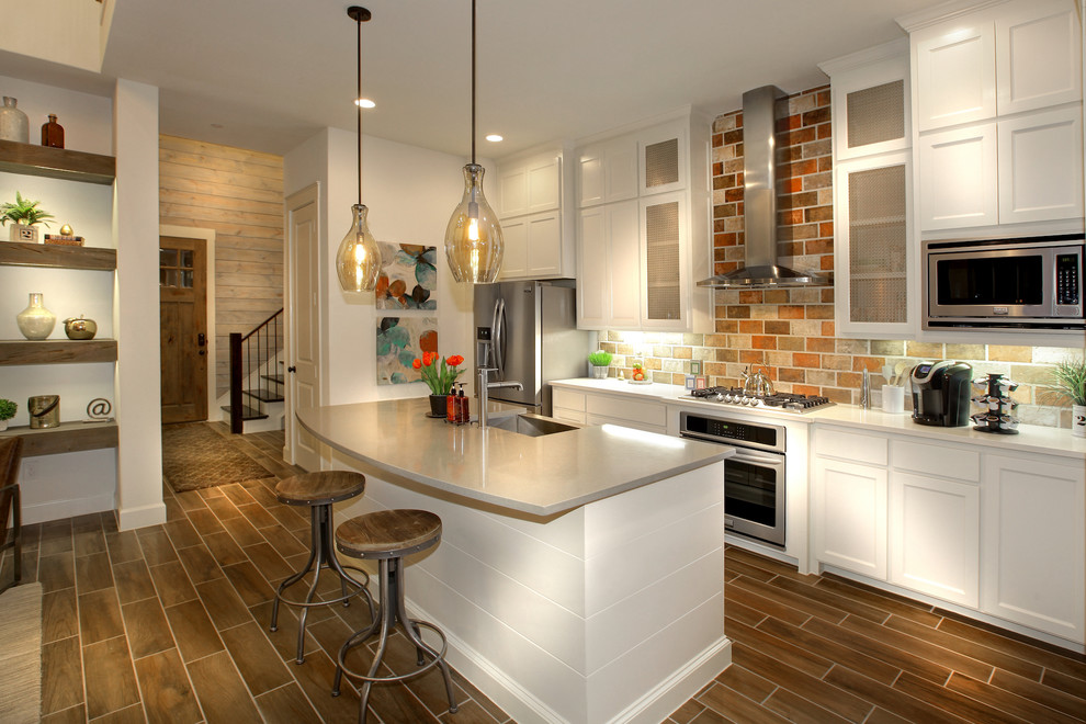 Example of a mid-sized classic single-wall ceramic tile eat-in kitchen design in Dallas with a farmhouse sink, shaker cabinets, white cabinets, multicolored backsplash, stainless steel appliances and an island