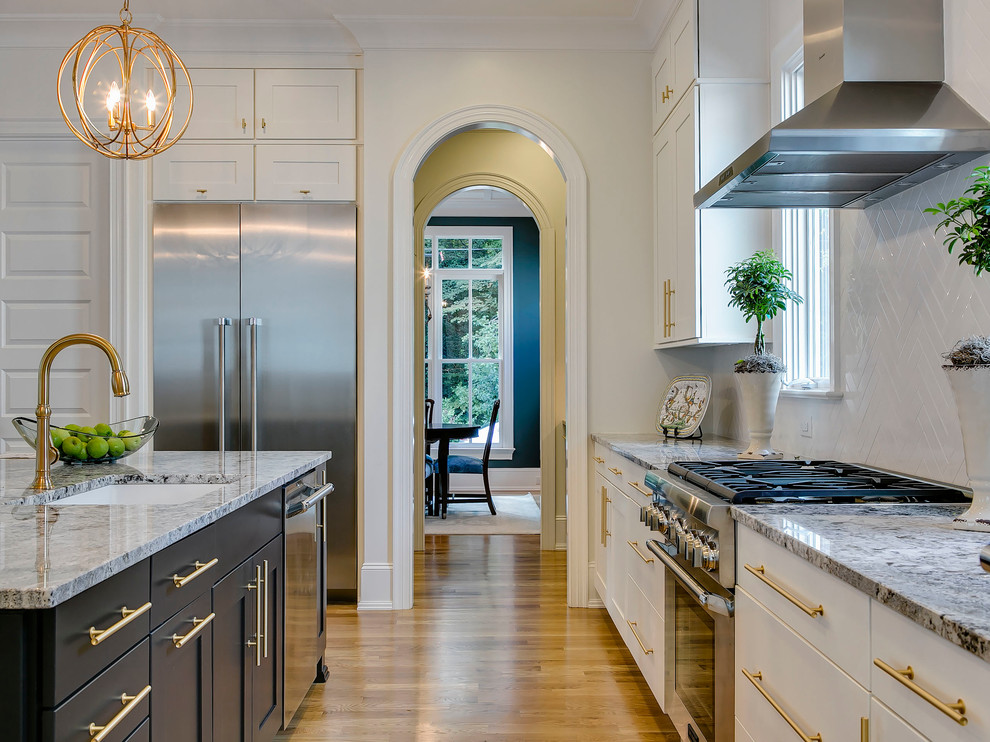 Design ideas for a classic l-shaped kitchen in Raleigh with a submerged sink, shaker cabinets, white cabinets, white splashback, stainless steel appliances, medium hardwood flooring, an island and granite worktops.