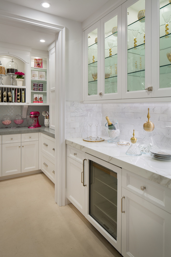 Large traditional galley kitchen pantry in Orange County with shaker cabinets, white cabinets, engineered stone countertops, white splashback, stone tiled splashback, integrated appliances and limestone flooring.
