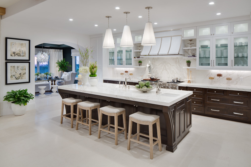 Design ideas for a large traditional l-shaped open plan kitchen in Orange County with shaker cabinets, white cabinets, engineered stone countertops, white splashback, stone slab splashback, integrated appliances, limestone flooring and an island.