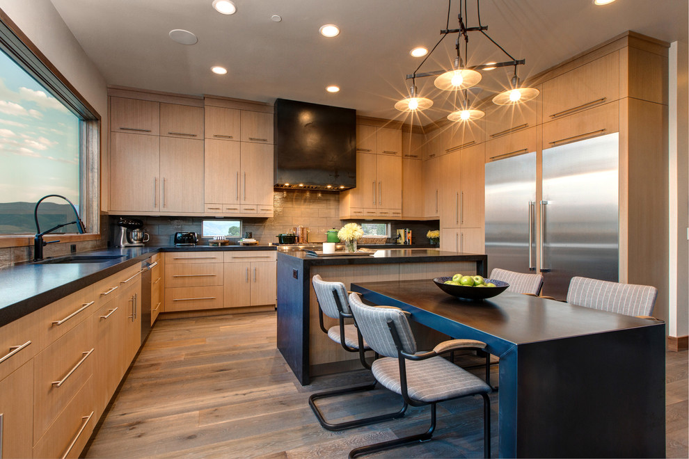 Moderne Küche in L-Form mit Unterbauwaschbecken, flächenbündigen Schrankfronten, hellen Holzschränken, Küchenrückwand in Beige, hellem Holzboden, zwei Kücheninseln und Granit-Arbeitsplatte in Salt Lake City