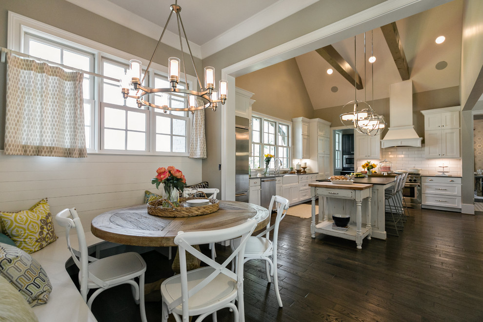 Kitchen - large transitional l-shaped dark wood floor kitchen idea in Birmingham with a farmhouse sink, shaker cabinets, white cabinets, quartzite countertops, white backsplash, cement tile backsplash, stainless steel appliances and an island