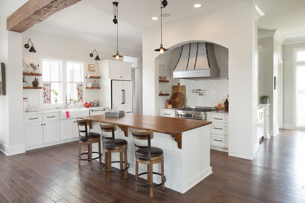 Geräumige Landhausstil Küche in U-Form mit Landhausspüle, weißen Schränken, Küchenrückwand in Weiß, Rückwand aus Metrofliesen und Kücheninsel in New Orleans