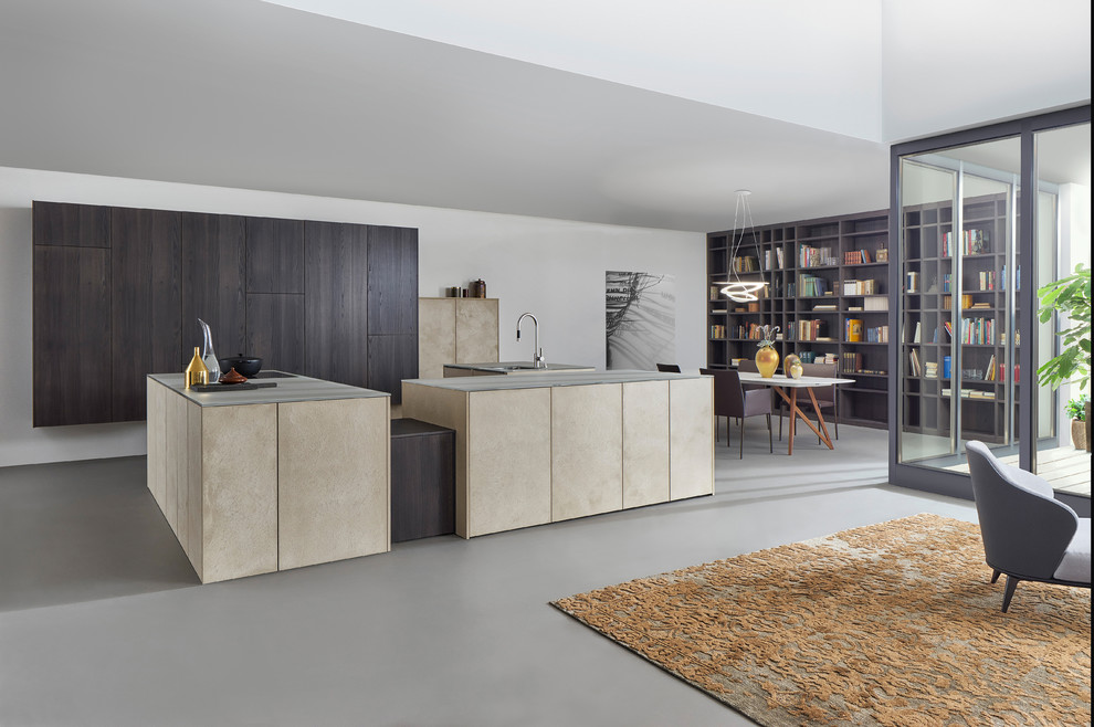 Esempio di una cucina moderna di medie dimensioni con lavello da incasso, ante lisce, ante beige, elettrodomestici in acciaio inossidabile, pavimento in cemento e 2 o più isole