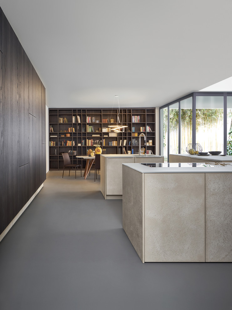 Medium sized modern u-shaped open plan kitchen in New York with a built-in sink, flat-panel cabinets, beige cabinets, stainless steel appliances, concrete flooring and multiple islands.
