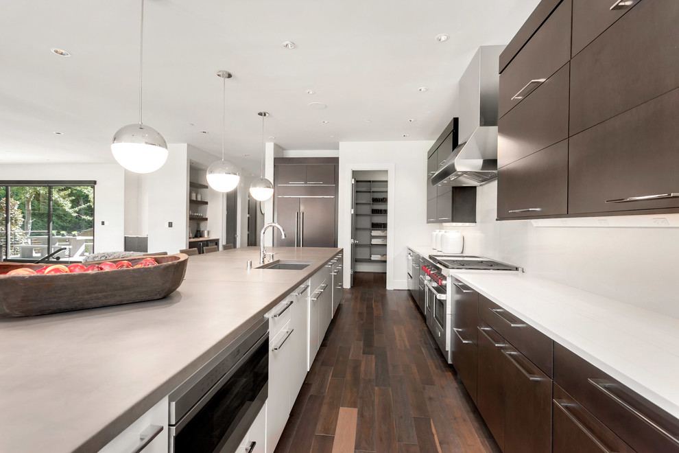 Inspiration for a large contemporary single-wall dark wood floor and brown floor eat-in kitchen remodel in Seattle with an undermount sink, flat-panel cabinets, dark wood cabinets, concrete countertops, white backsplash, stainless steel appliances and an island
