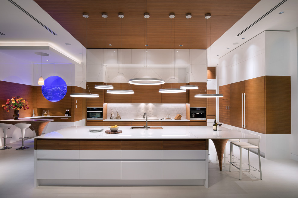 Moderne Küche mit flächenbündigen Schrankfronten, weißen Schränken, Küchenrückwand in Weiß, weißem Boden, Unterbauwaschbecken, Kücheninsel und weißer Arbeitsplatte