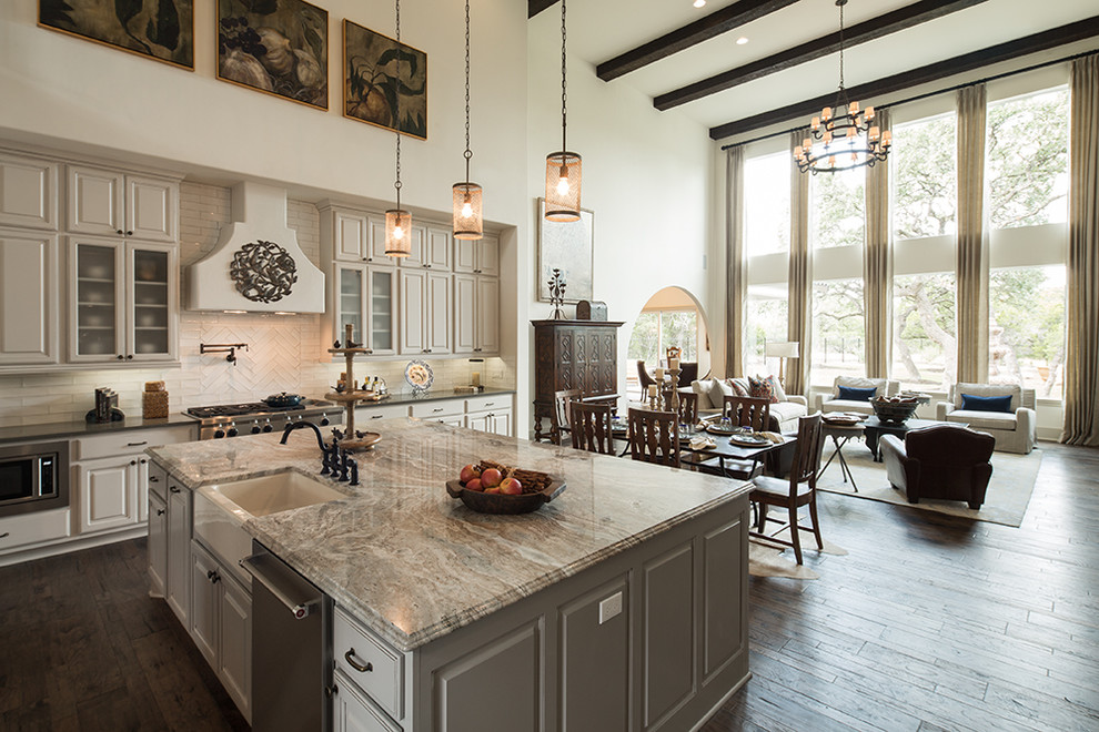 Bild på ett medelhavsstil kök, med en rustik diskho, vita skåp, vitt stänkskydd, rostfria vitvaror, mörkt trägolv, en köksö och brunt golv